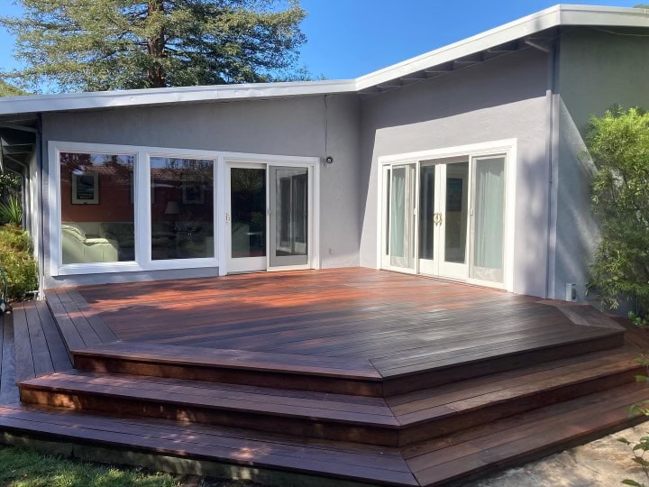 Wooden deck outside modern house with large windows