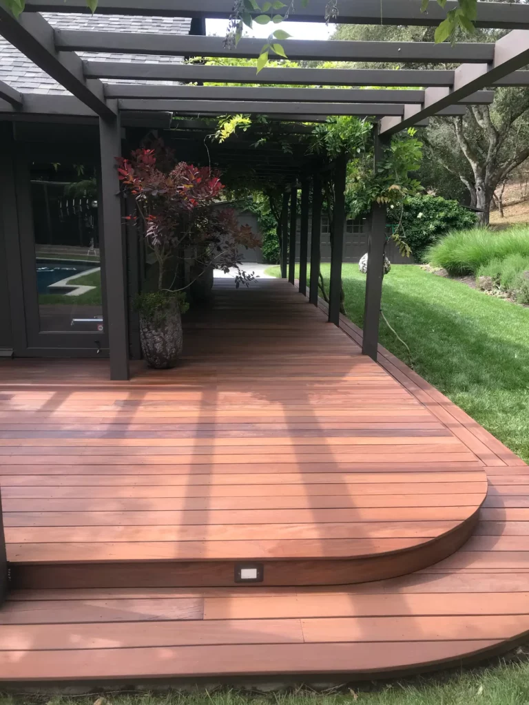 Wooden deck with pergola and landscaping.