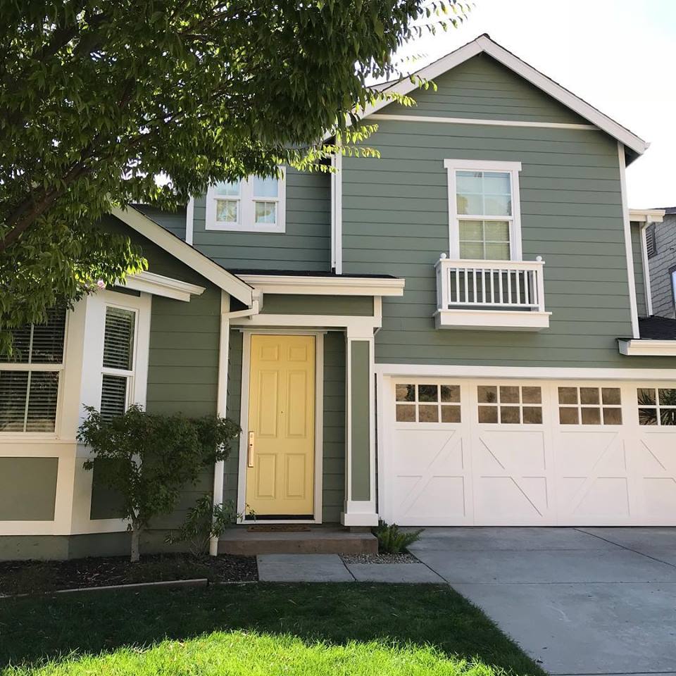 oKRHGWW2MsfH Green suburban house with yellow door and garage