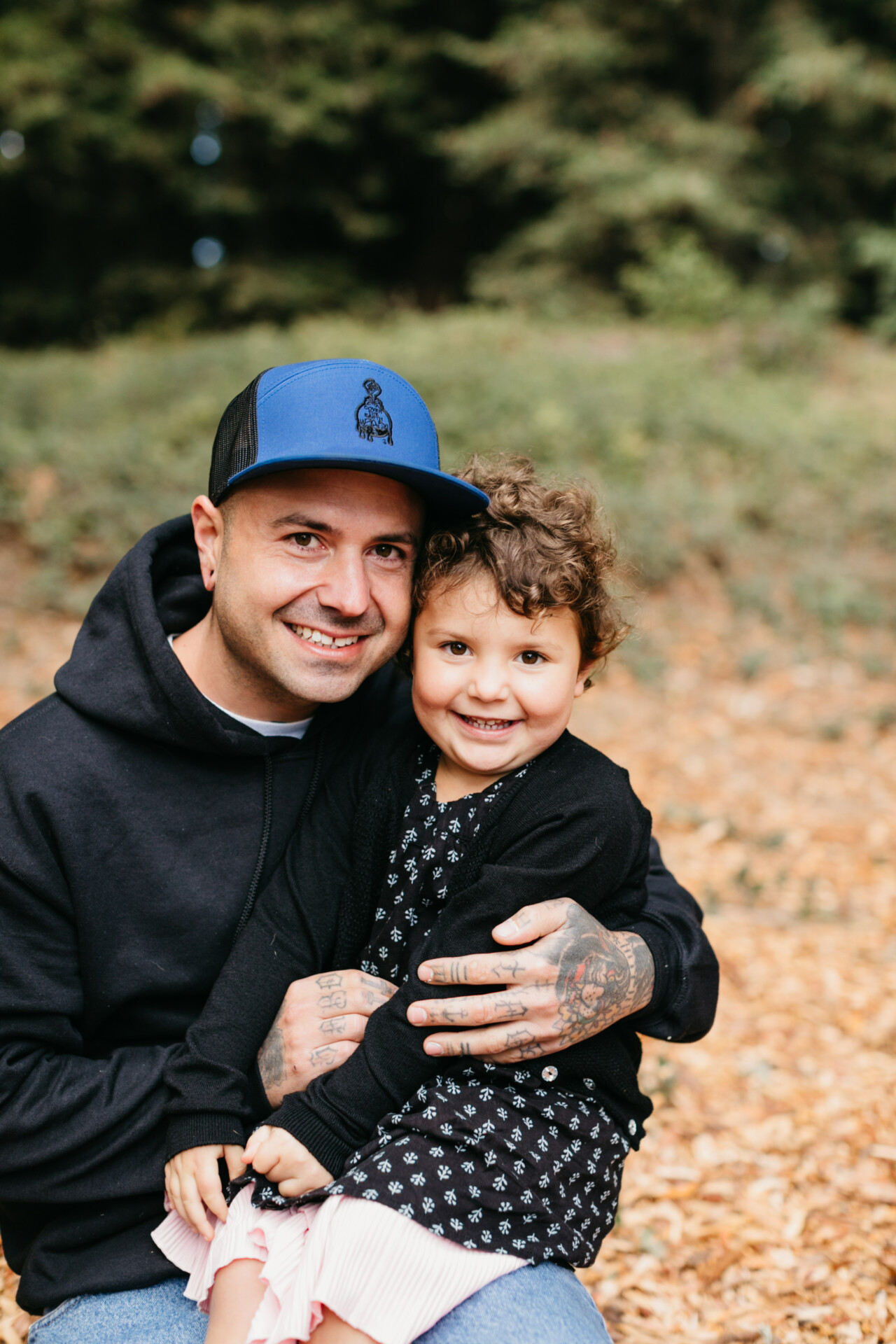 Father and child smiling in autumn park.