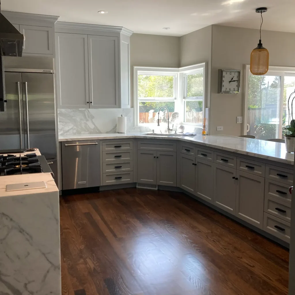 Modern kitchen with gray cabinets and hardwood floors.