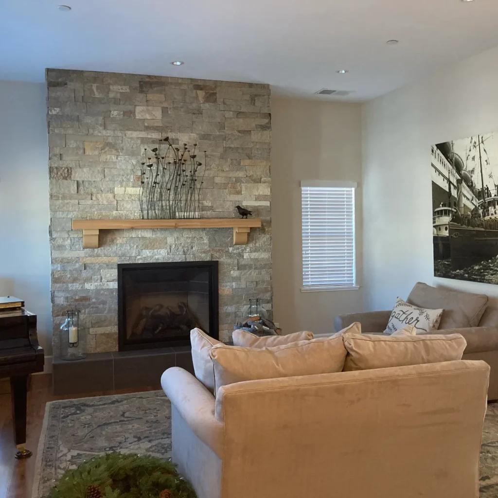 Cozy living room with fireplace and stone wall.