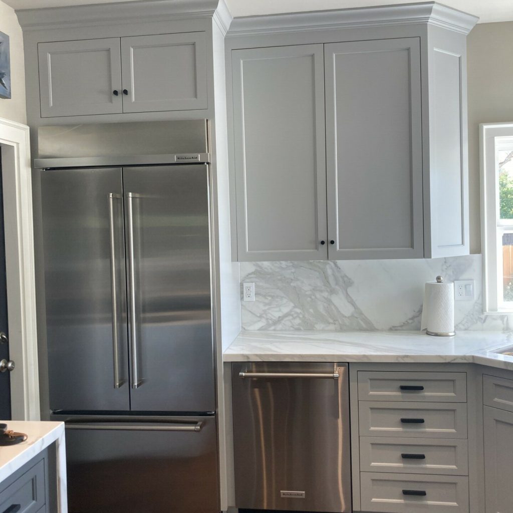 Modern kitchen with stainless steel appliances and gray cabinets.